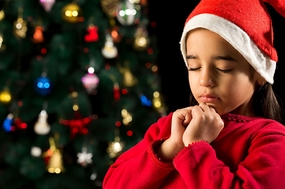 欧美小女孩戴着圣诞帽许愿图片